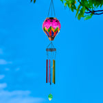 Colorful glass solar hot air balloon lantern with a hanging wind chime for backyard decorations, patio décor, and garden solar lights featuring a warm flame-effect glow