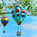 Garden solar decor featuring a hand-painted beetle balloon lantern hanging over a patio, great for patio decor ideas