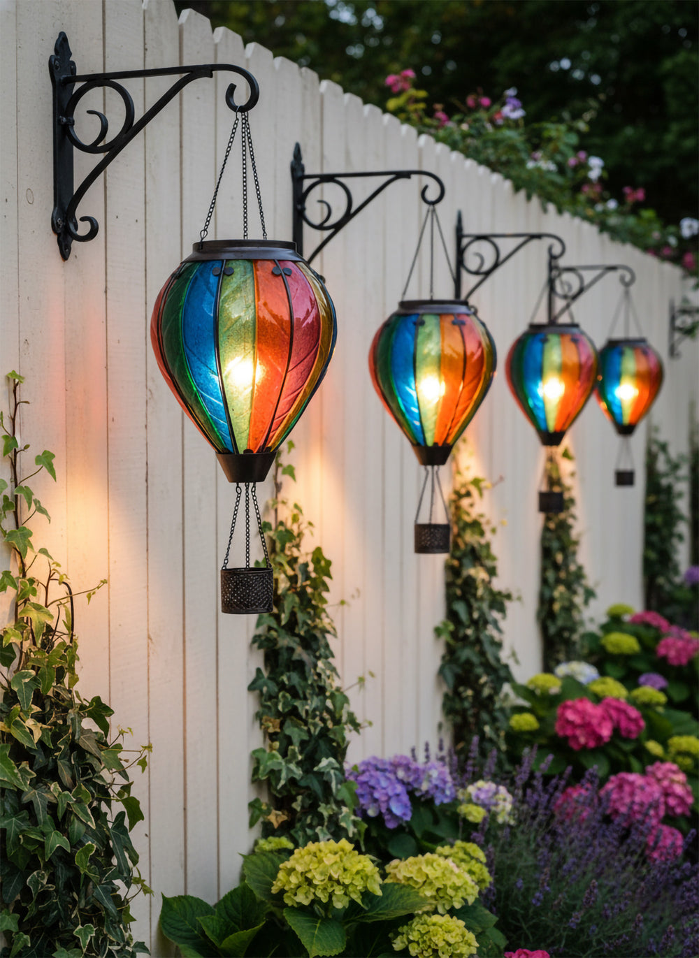 Illuminated hot air balloon solar lanterns glowing in a garden at dusk