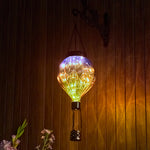 Purple hand-painted solar hot air balloon lantern for backyard decorations, patio decor, and garden solar lights with a warm flame-effect glow