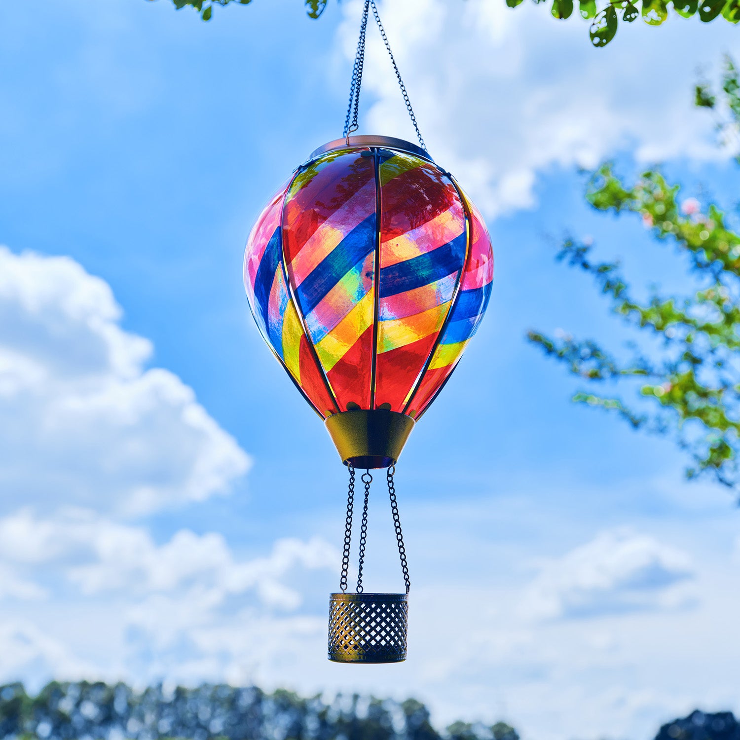 Rainbow hot air balloon solar lantern glowing in the backyard, ideal for colorful backyard decorations and solar garden decor.