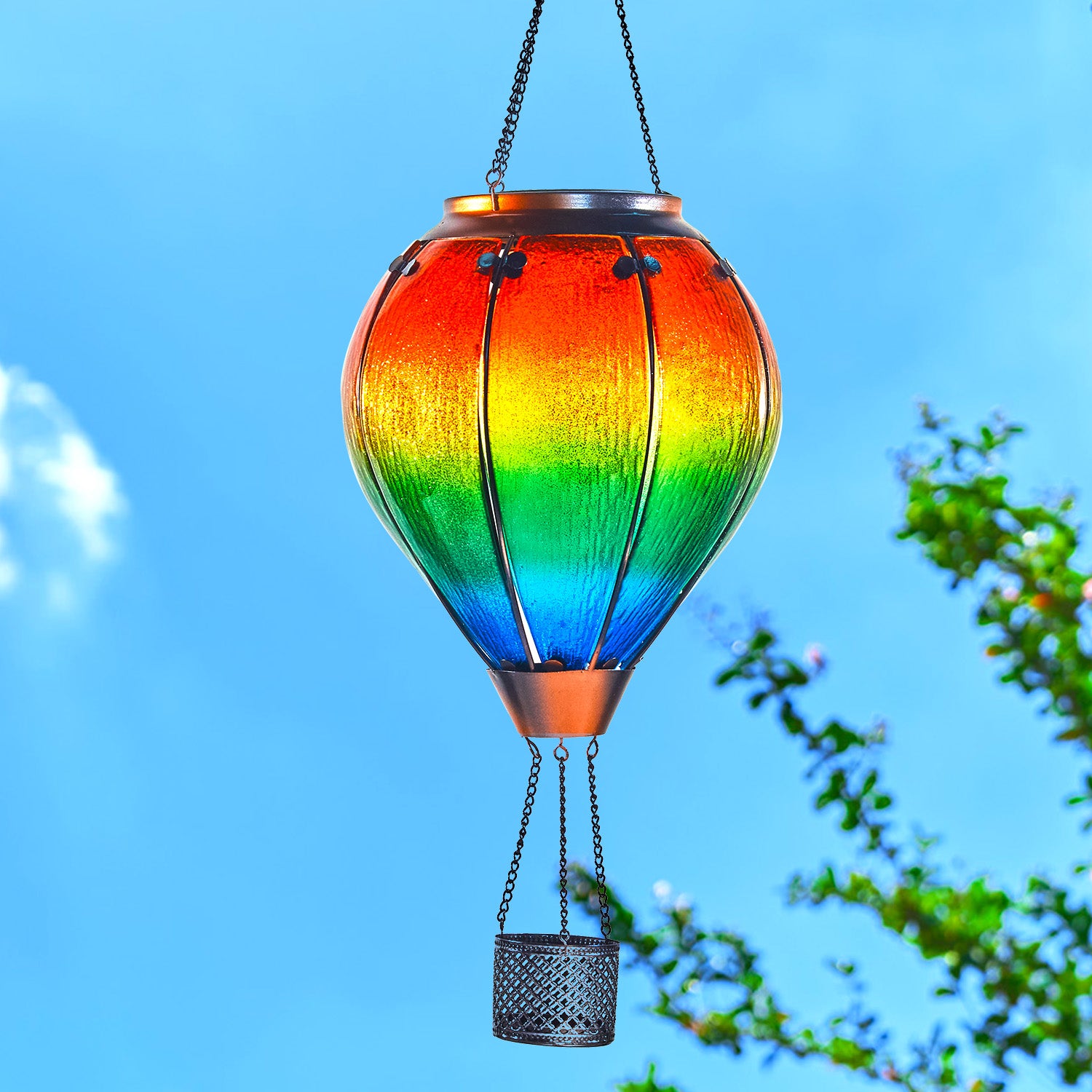 Rainbow hot air balloon lantern glowing in backyard foliage, perfect for solar garden lights and backyard solar lighting