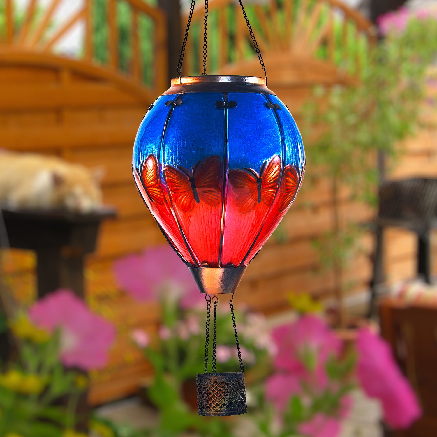 Hand-painted butterfly solar balloon lantern illuminating a patio, great for patio decor ideas and solar garden decorations