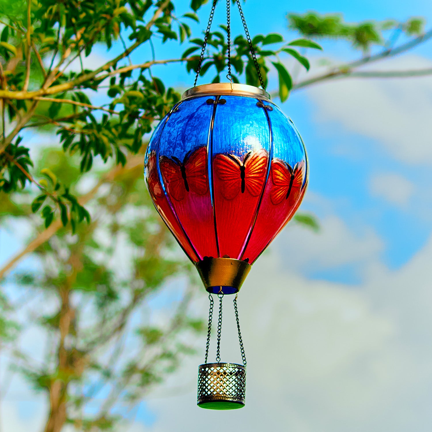 Butterfly-themed solar lantern with flame effect lighting up a cozy backyard, perfect for backyard solar lights and yard decor