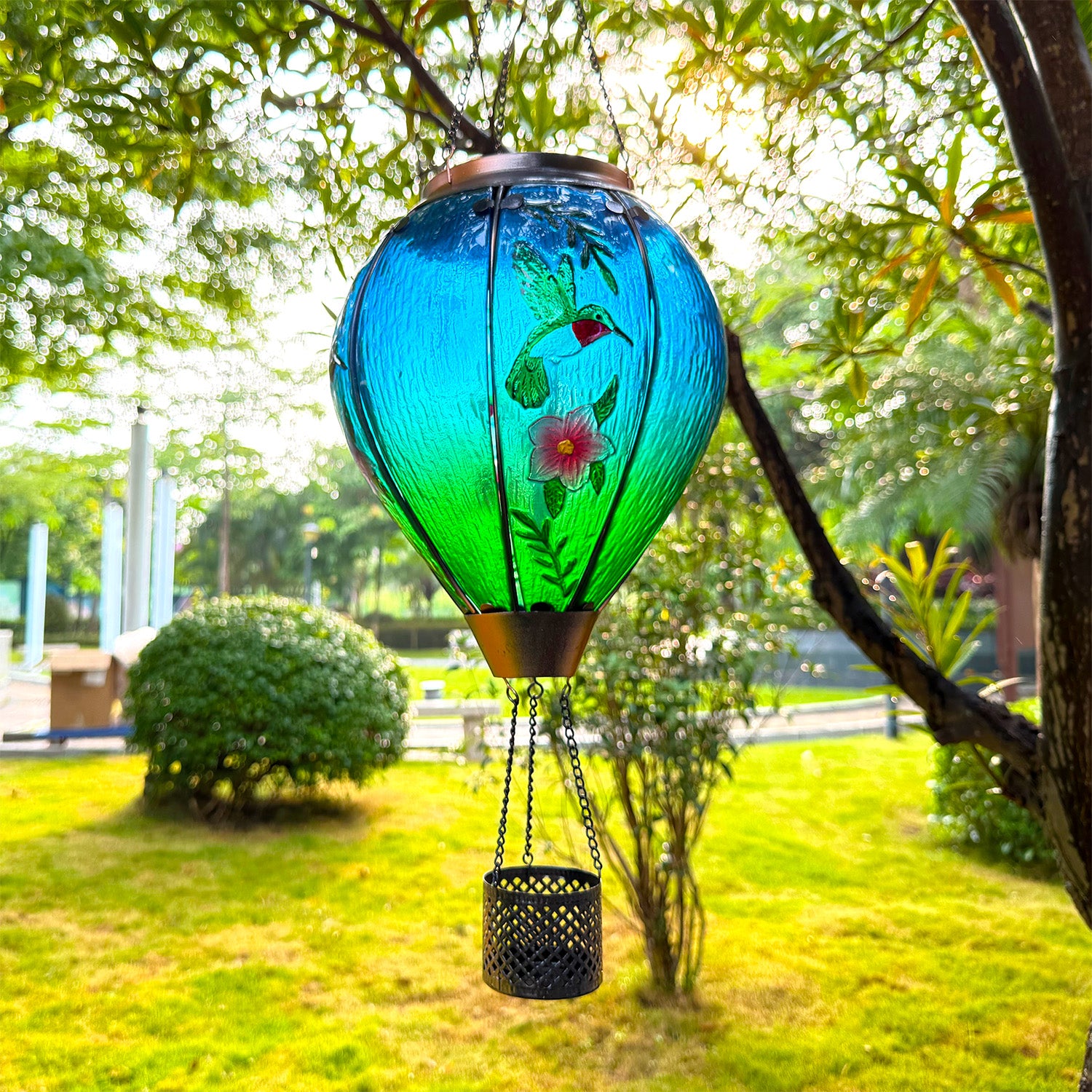 hand-painted glass hummingbird hot air balloon solar lantern in sunlight for garden decor