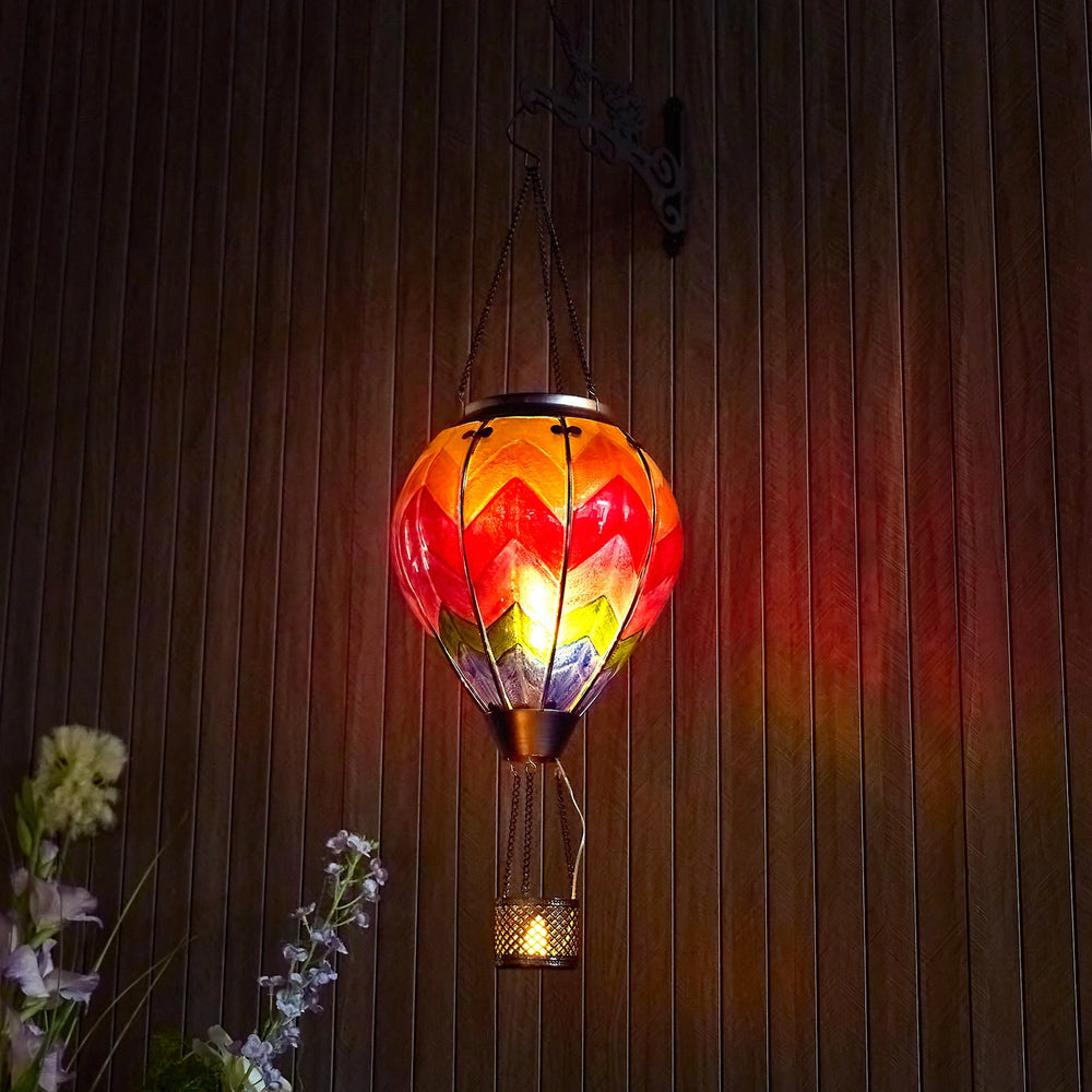 Hot air balloon solar lantern glowing on a garden porch at night