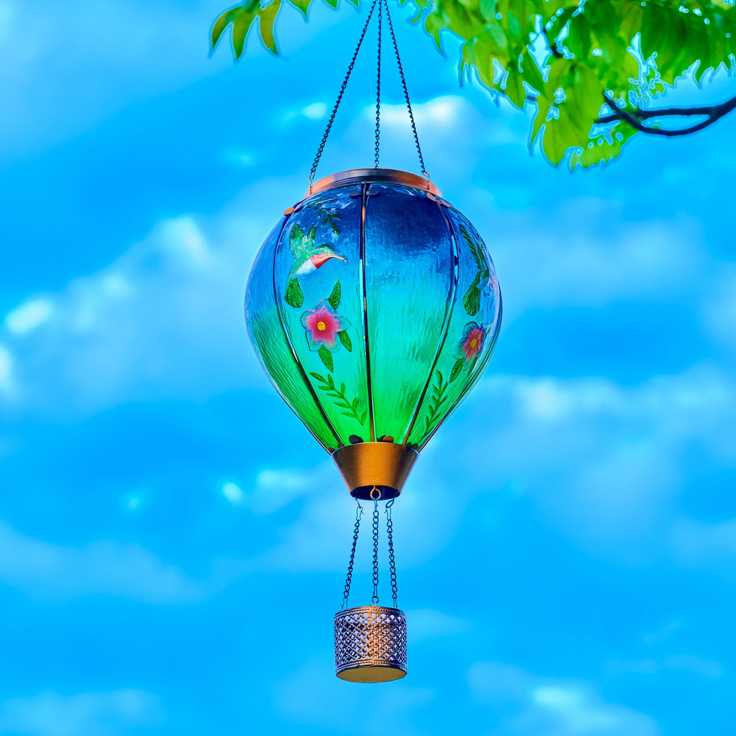 Solar hummingbird balloon lantern hanging on a patio tree, ideal for patio decor ideas and yard decorations with artistic flair