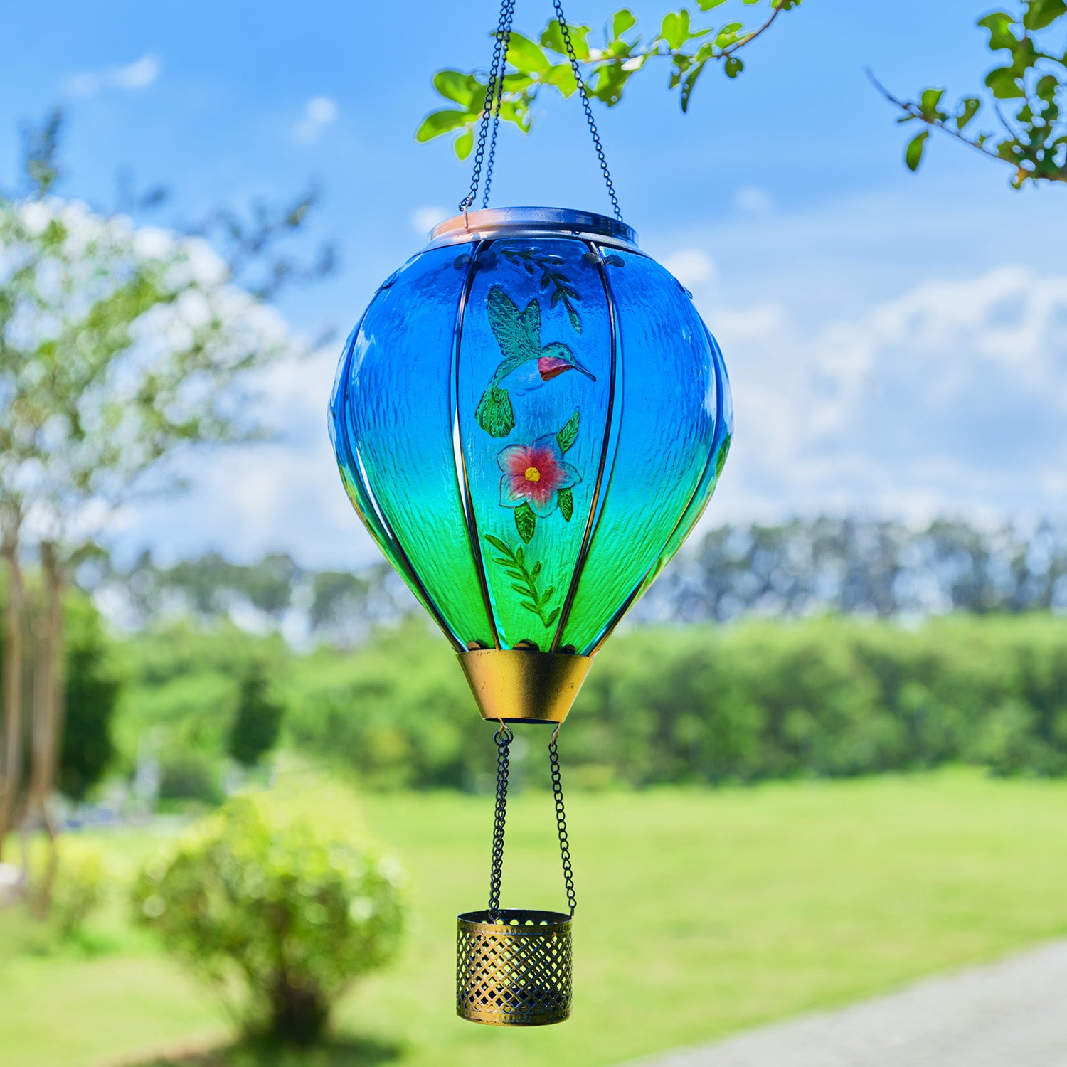 Solar hummingbird balloon lantern hanging on a patio tree, ideal for patio decor ideas and yard decorations with artistic flair