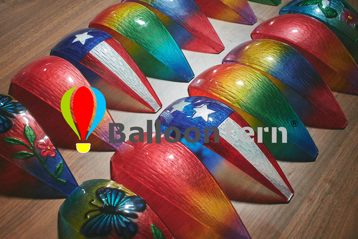 Close-up of brush painting peacock tones onto a glass solar lantern panel, part of the handcrafted process