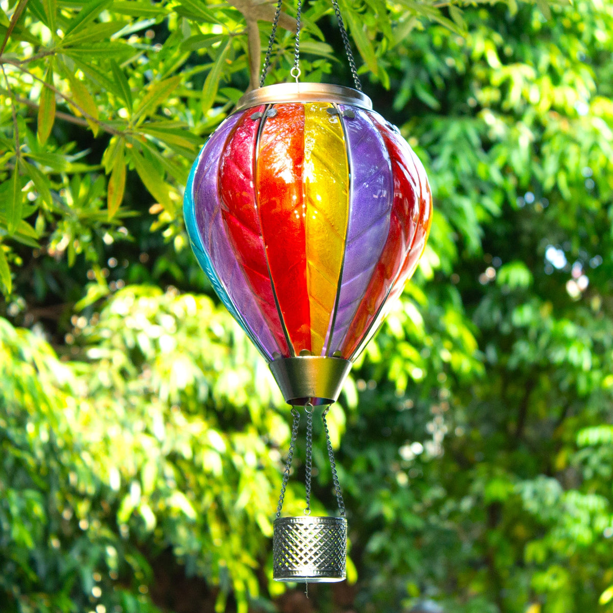 Vibrant rainbow solar balloon lantern displayed in a colorful backyard garden